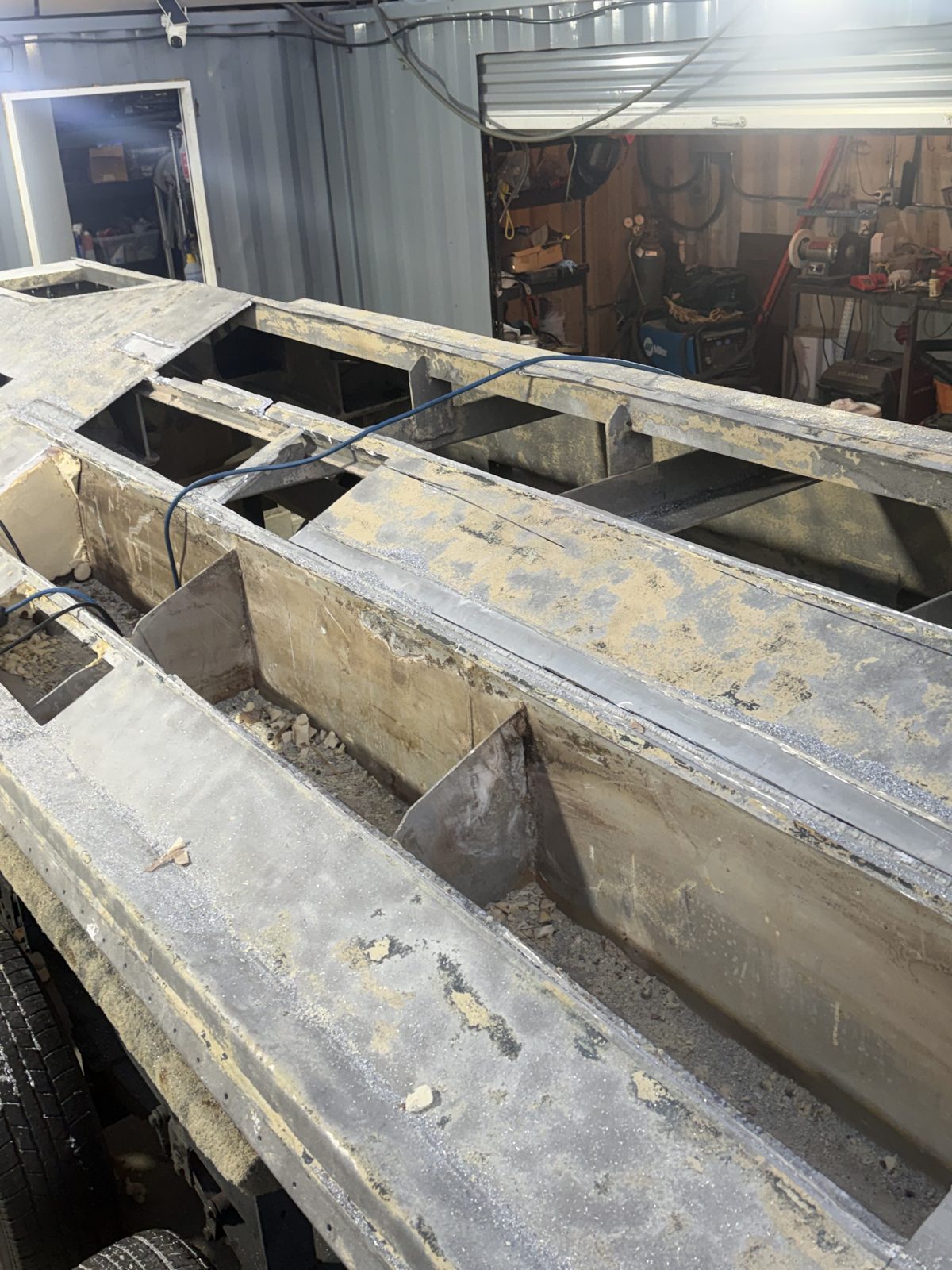 Aluminum hull opened up in the shop with corroded stringers and frames exposed for replacement
